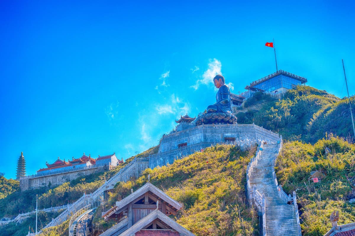 What to Do in Vietnam: Top 10 Must-Dos 4 Fansipan Peak challenges climbers with clouds swirling around its rugged summit.