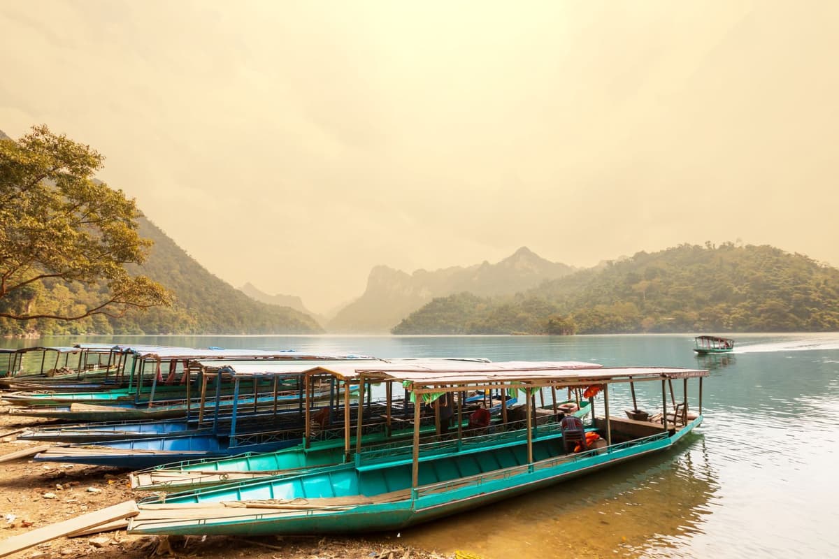 Mặt nước hồ Ba Bể phẳng lặng như gương phản chiếu núi non và mây trời