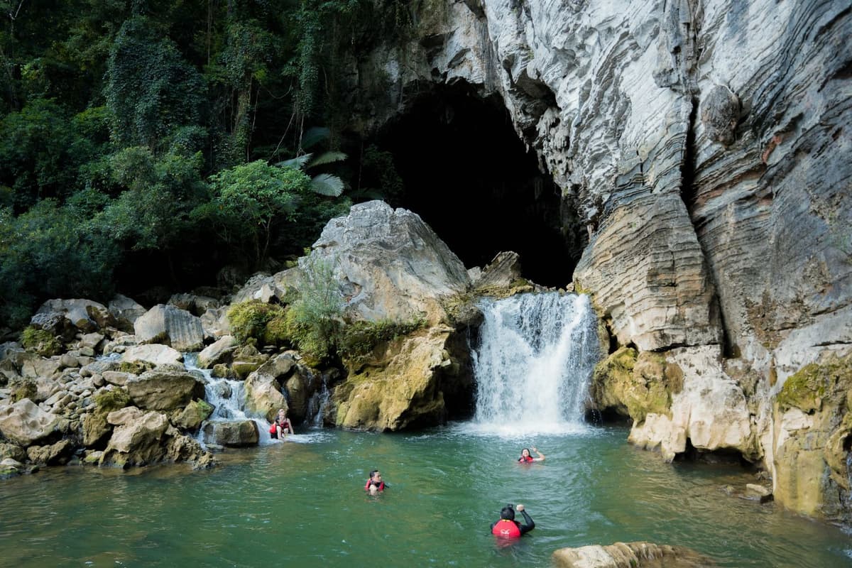 Experience cave adventures and underground river swimming in the Tu Lan Cave System during summer
