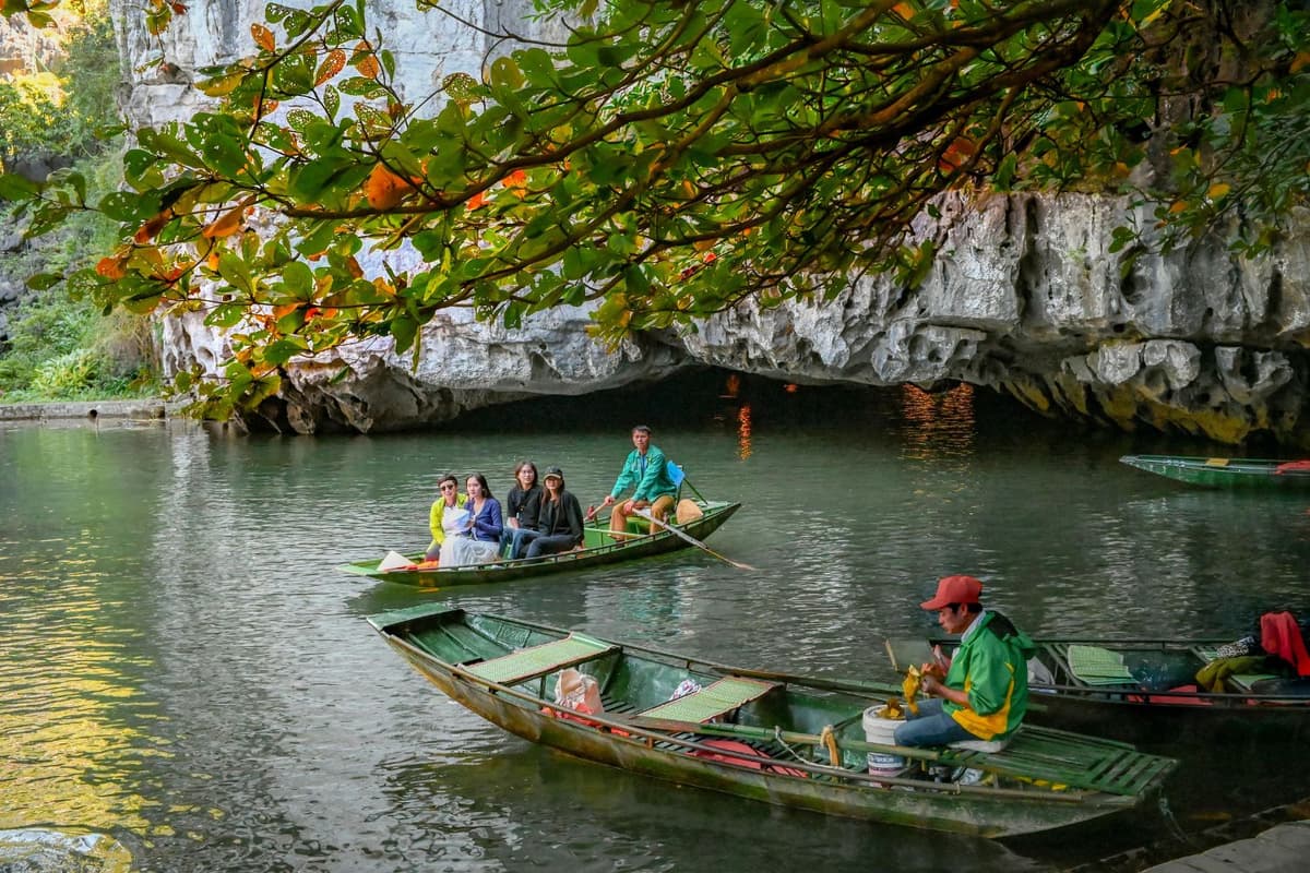 Thuyền du lịch chở khách trên dòng sông Tràng An Ninh Bình xung quanh là núi đá vôi