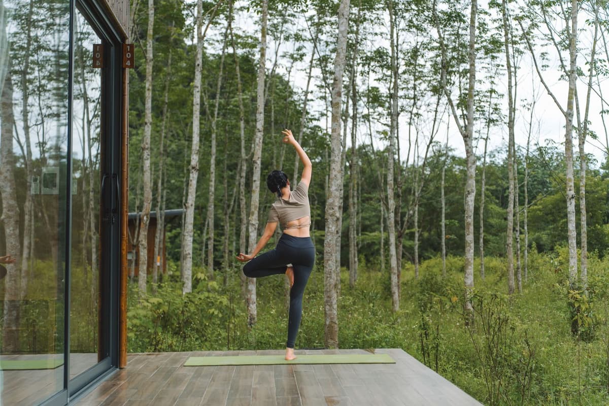 Blue Diamond Retreat: A Nature-Inspired Retreat in Phong Nha - Ke Bang 8 A traveler practices yoga on the veranda of a Jungle Bungalow